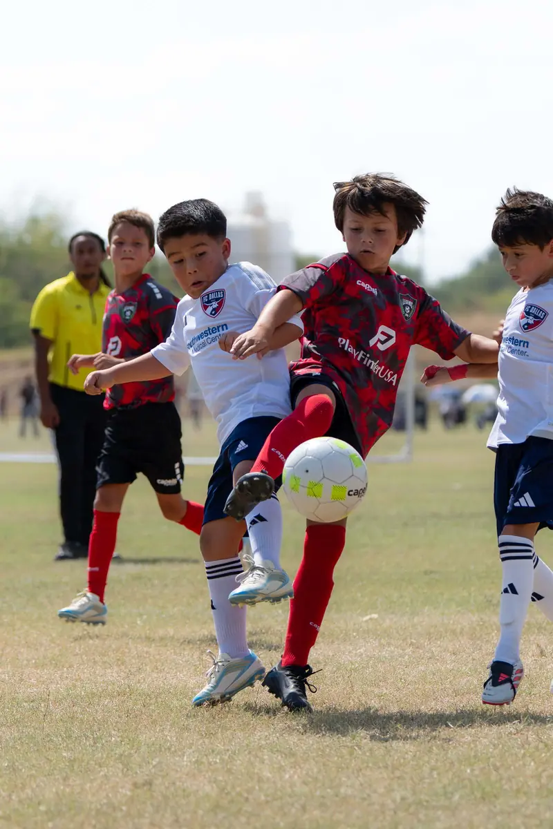 Two FC Dallas youth players battling for the ball at a Dallas tournament