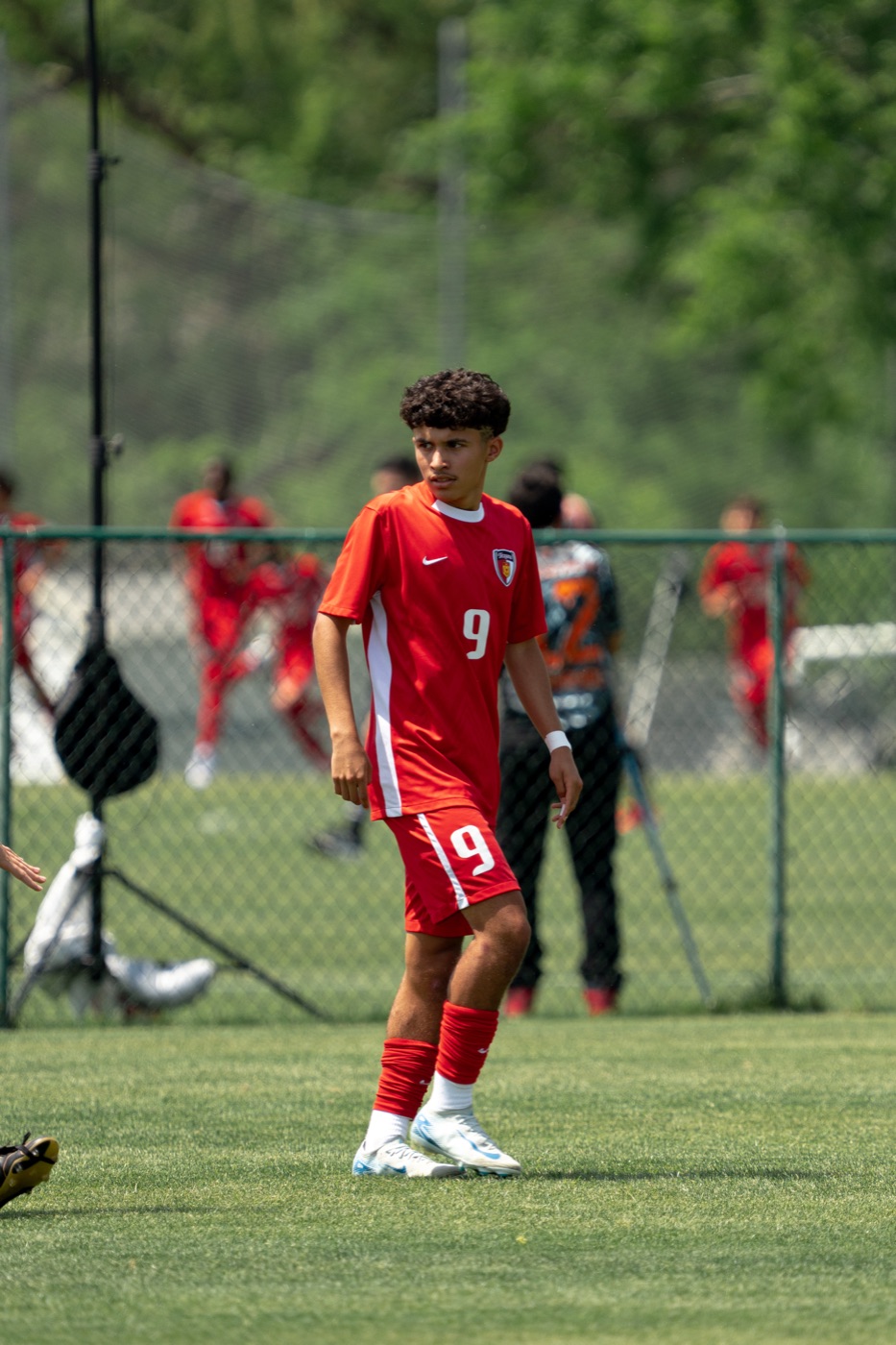 Youth soccer player in a red kit on the field