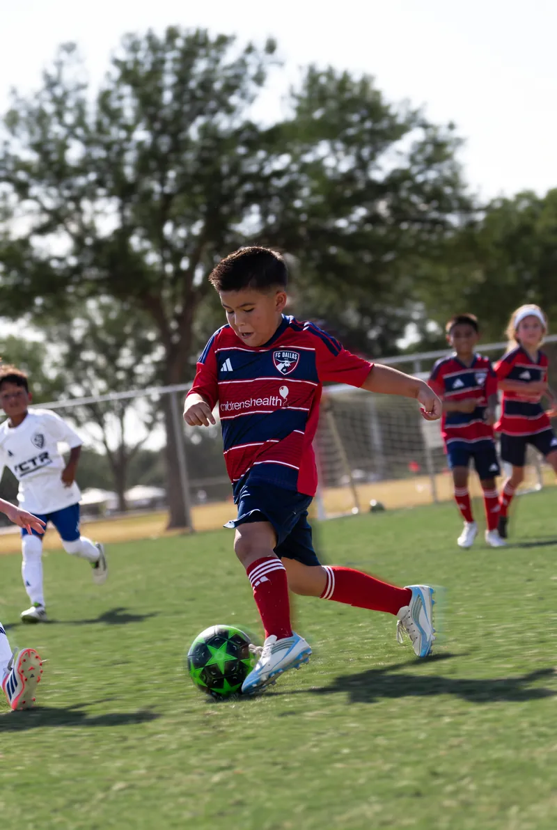FC Dallas youth player number 5 dribbling at speed with the ball at his feet