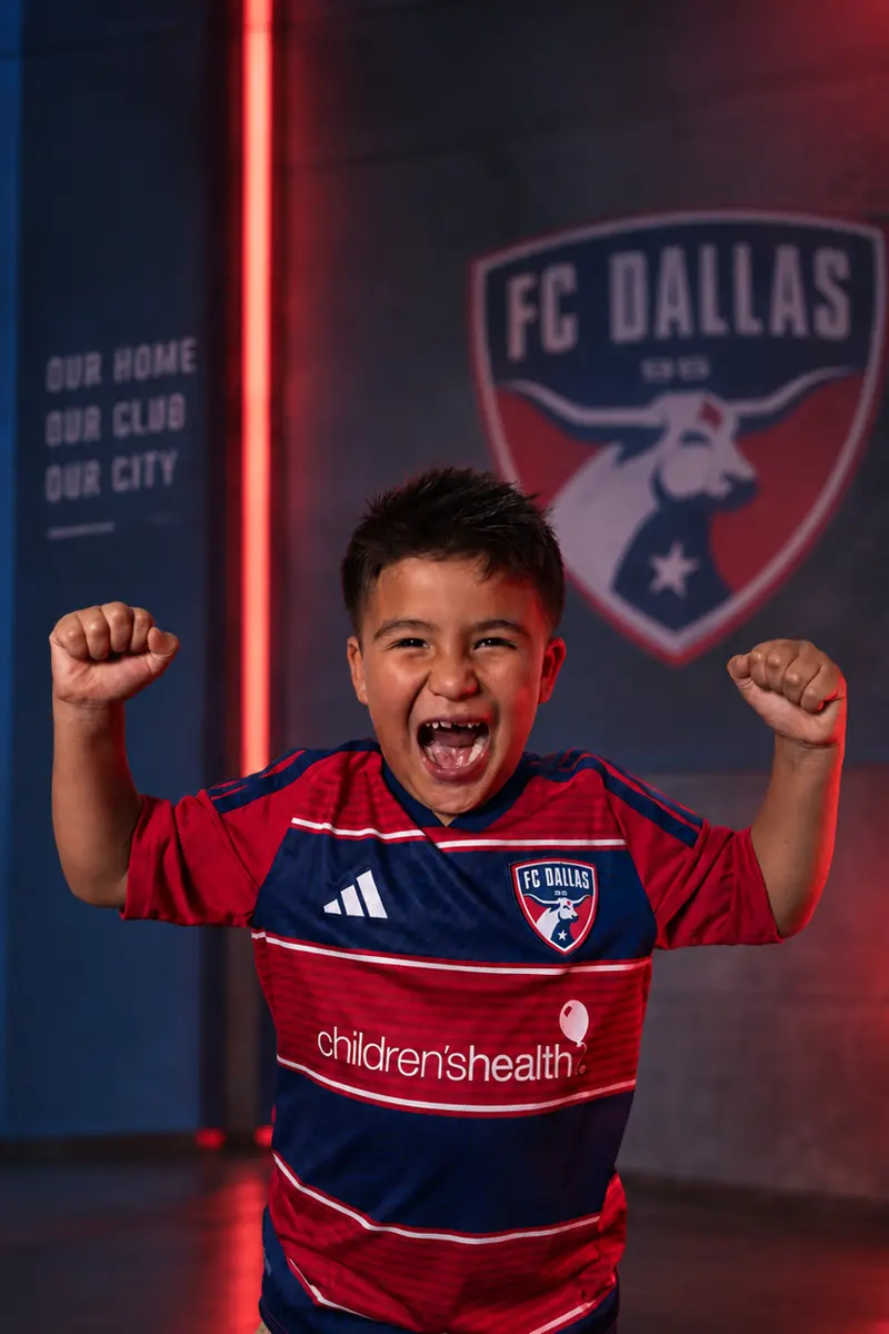 Youth player celebrating with both fists up, media day edit with red light bars