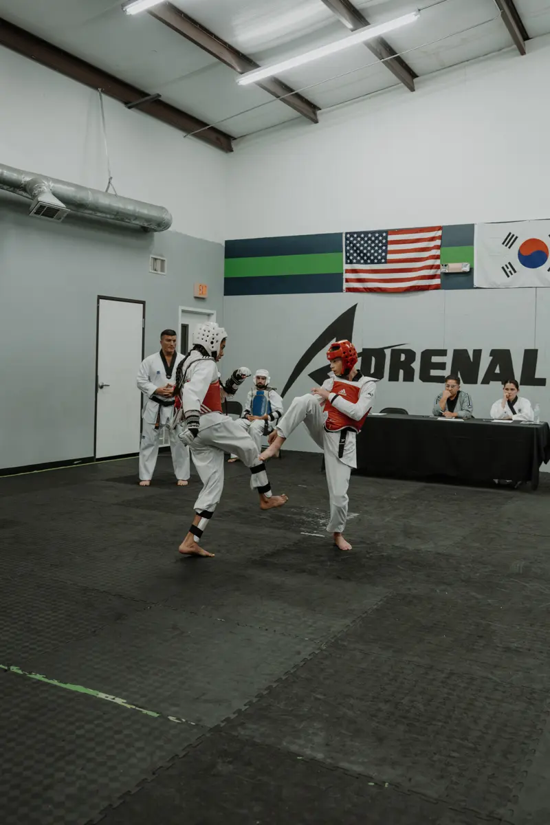 Two taekwondo students sparring in headgear and chest guards